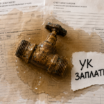 Залитая стена и размокшие документы на столе, иллюстрирующие ущерб от залива квартиры по вине управляющей компании.